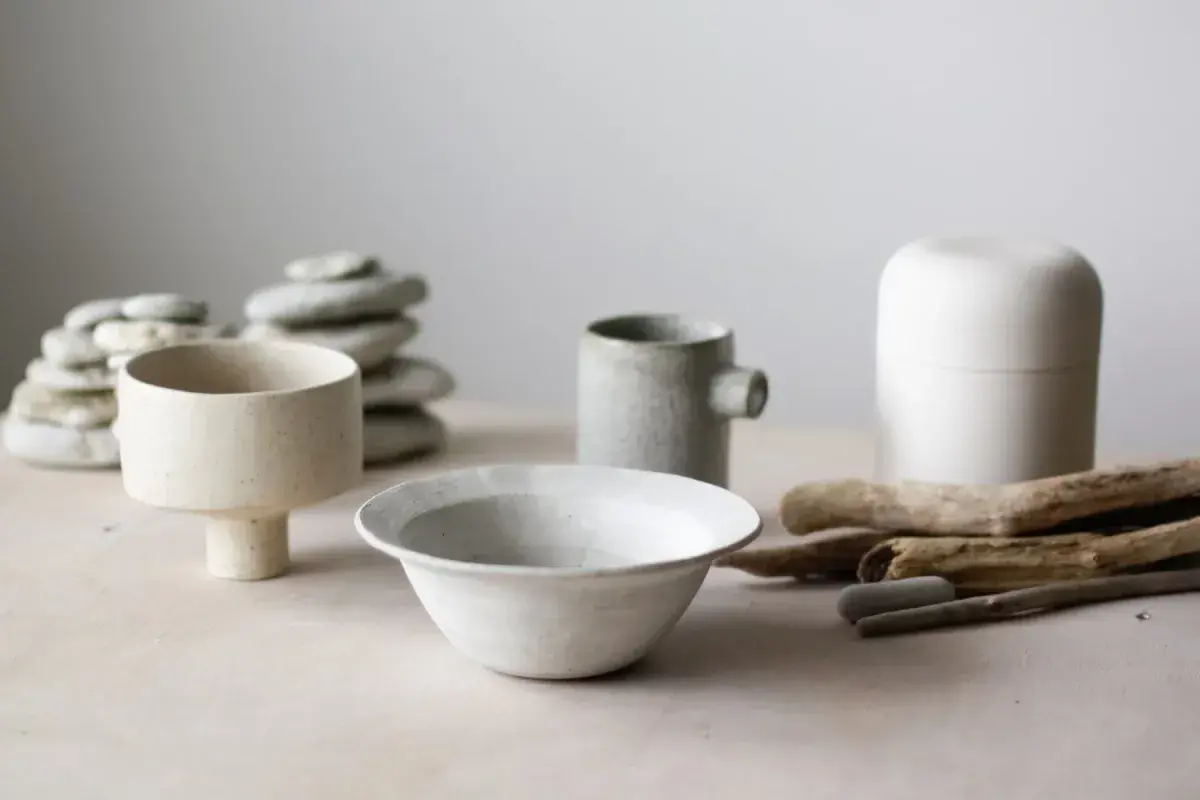 Handmade ceramic vessels arranged on wooden shelf