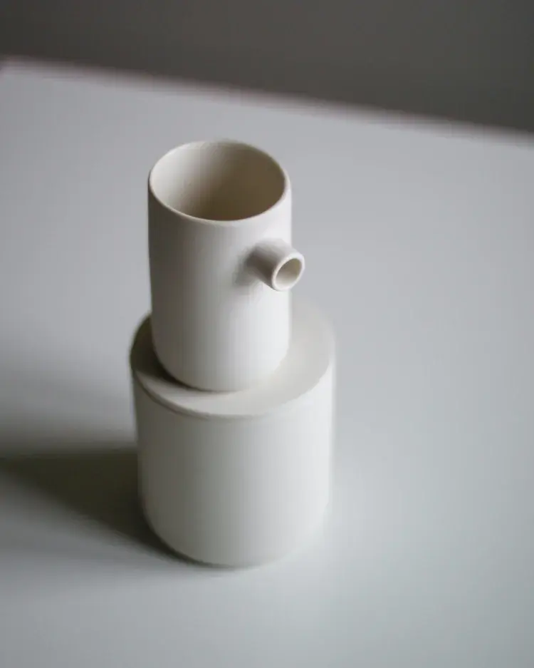 Slip-cast creamer with curved spout and handle