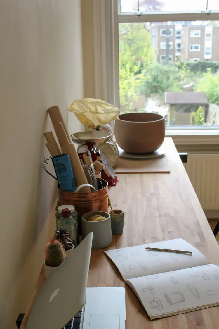 Pottery studio workspace with shelves of ceramics