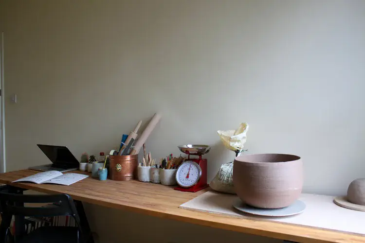 Hand-built ceramic bowls drying on studio shelf