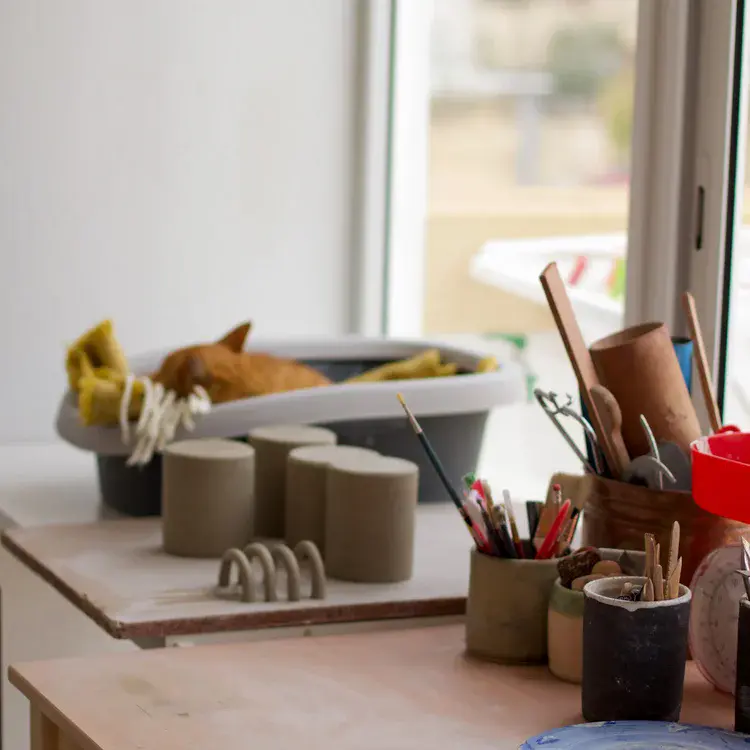 Collection of handmade mugs lined up on workbench