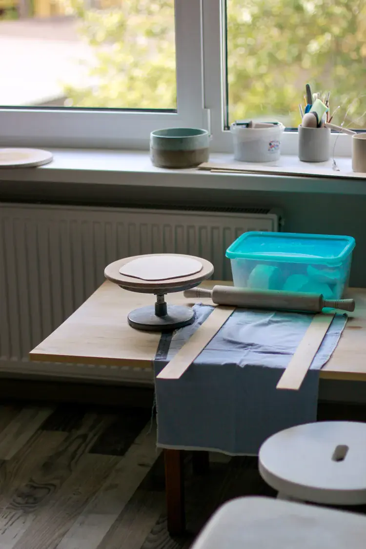 Stacked ceramic plates drying between studio sessions