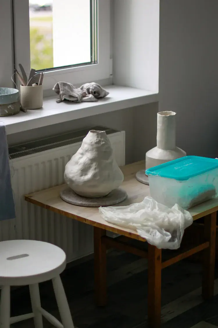Glaze bottles and pigments organized on studio shelf