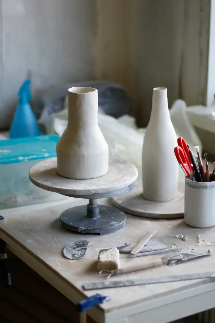 Sponges, ribs, and trimming tools beside the wheel