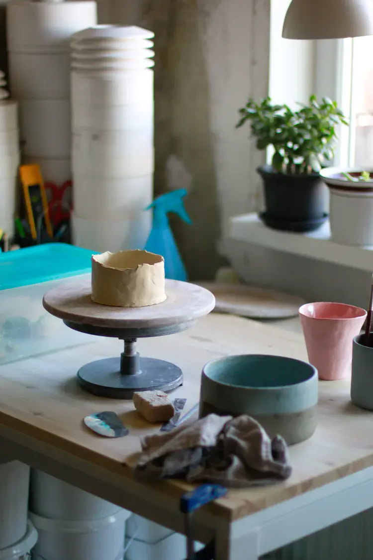 Rows of hand-thrown cups and tumblers on shelf